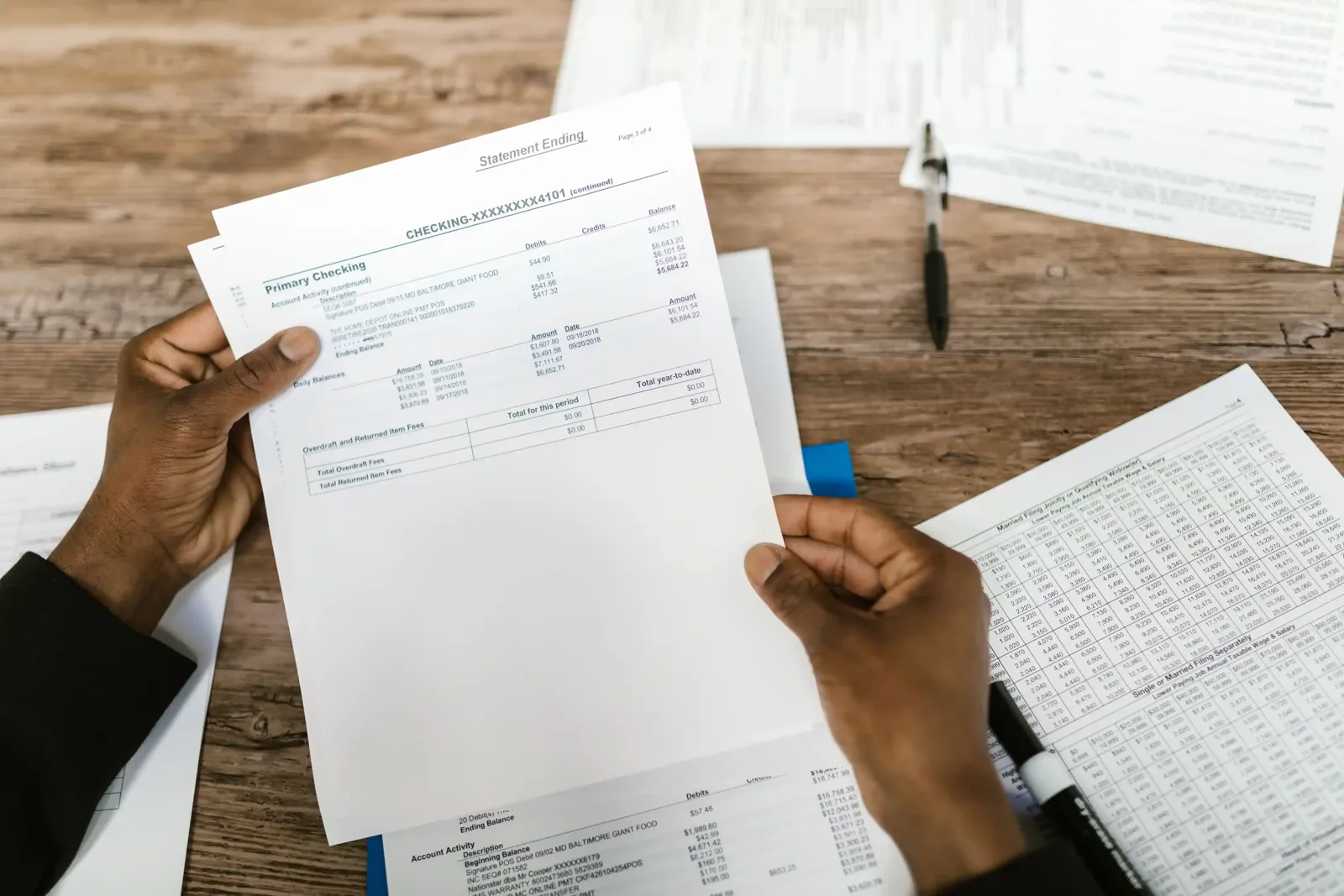 Person reviewing a bank statement highlighting various fees, 2026 banking guide